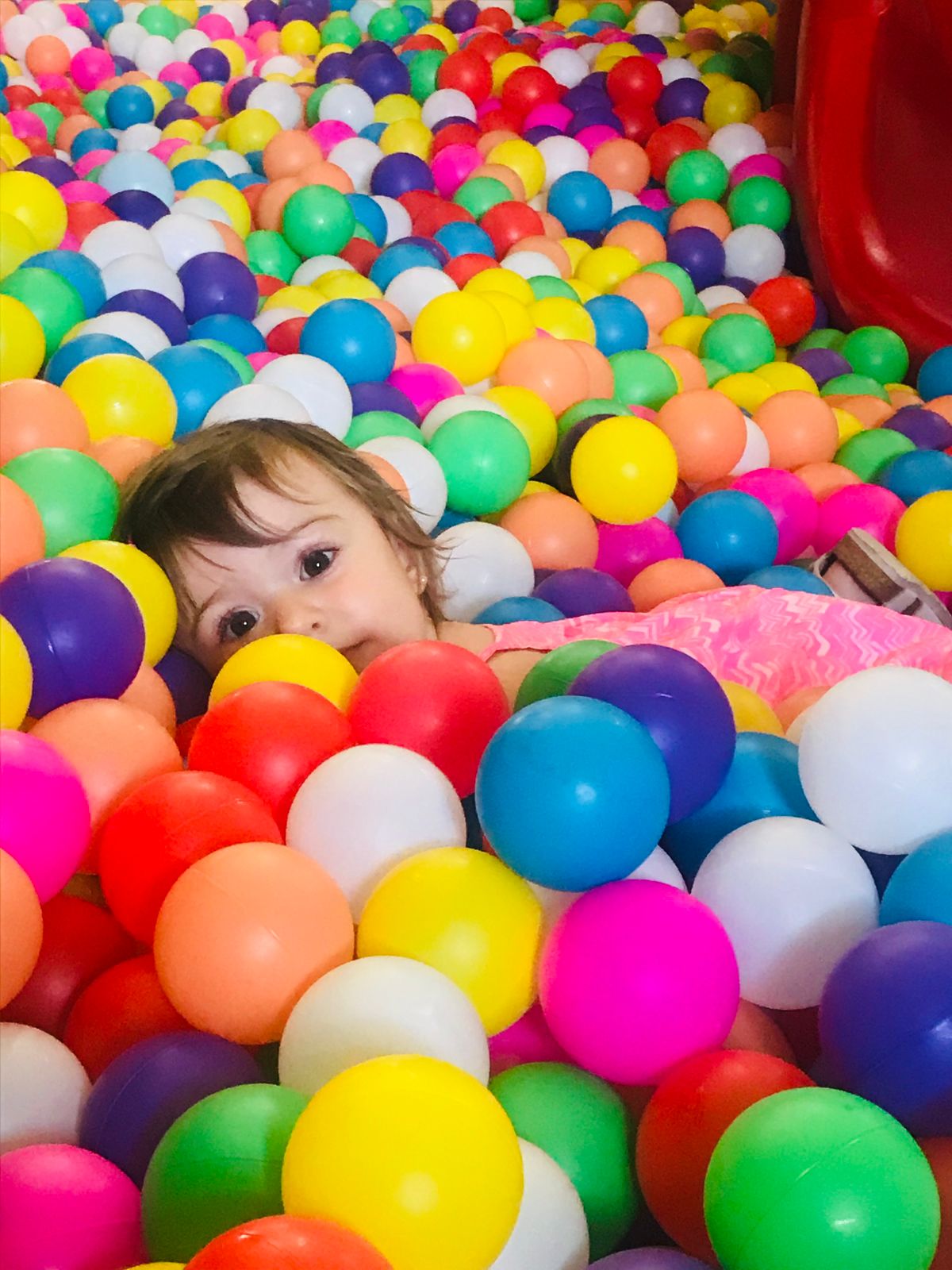 Bebé en piscina de pelotitas multicolor
