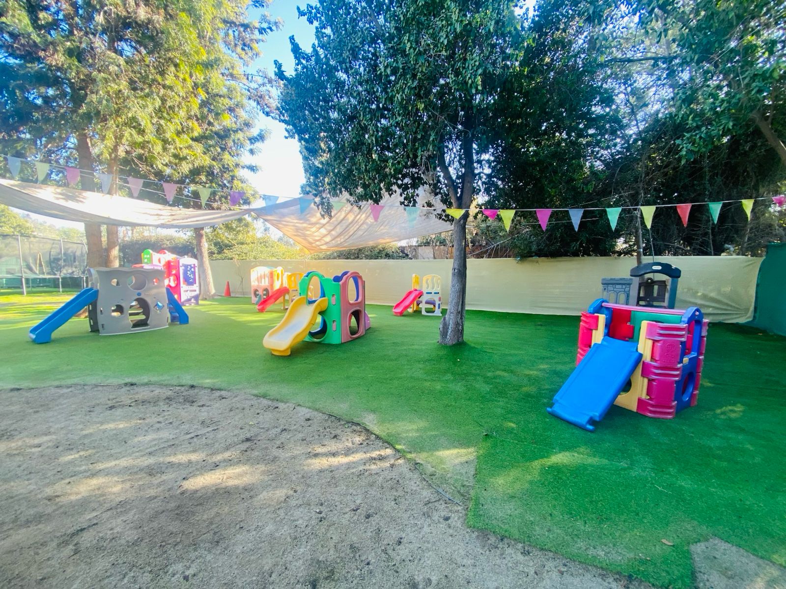 Patio con módulos y banderines bajo toldo