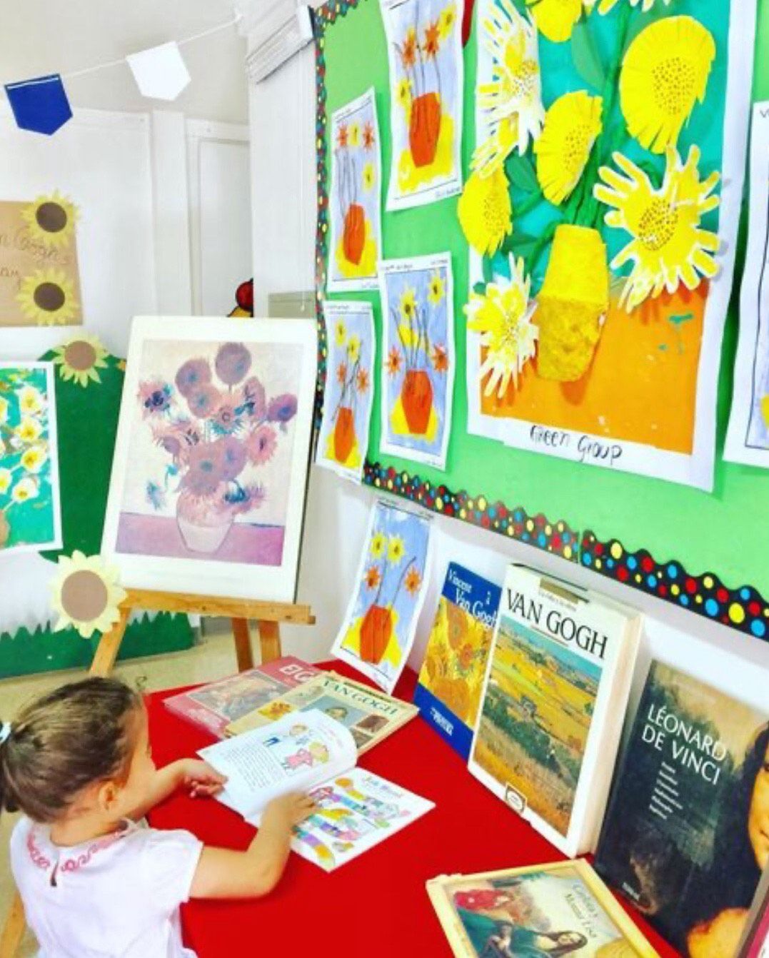 Niña con libros de Van Gogh frente al mural