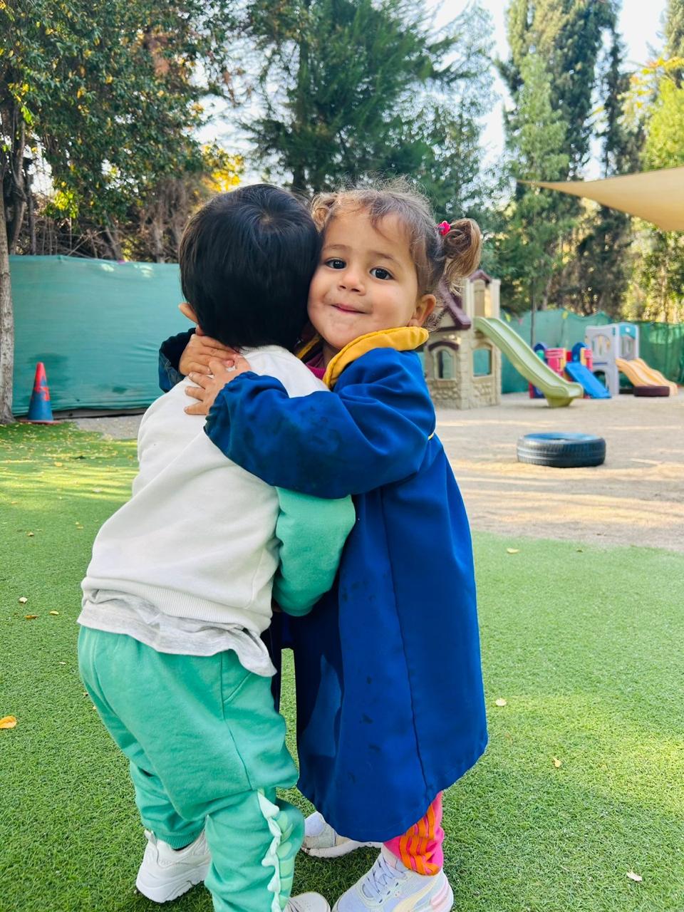 Dos niños abrazándose en el patio